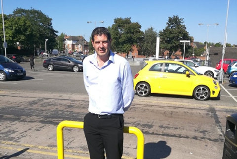 Cllr Cook stood in front of a car park
