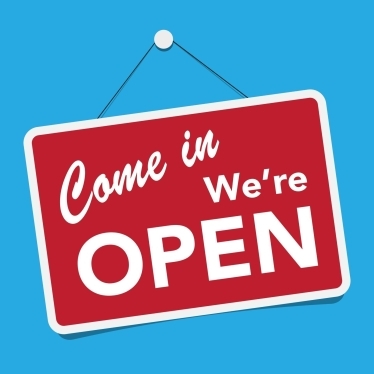 a red sign that says 'come in we're open' on a blue background