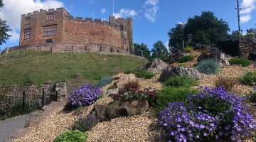 Tamworth Castle behind flower beds with purple and green flowers