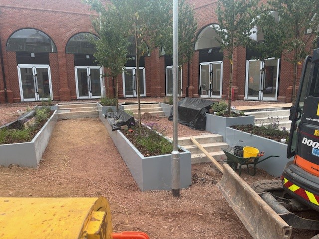 image of new paving and planters with trees being laid