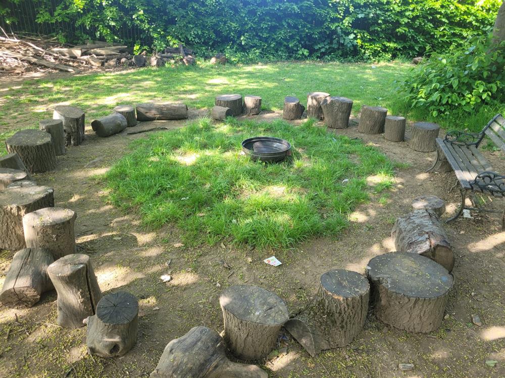 A circle of logs outside a circle of grass