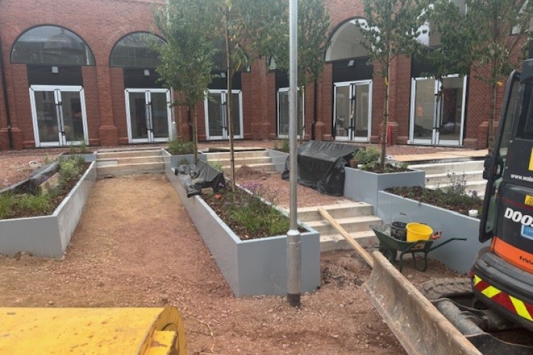 image of new paving and planters with trees being laid 