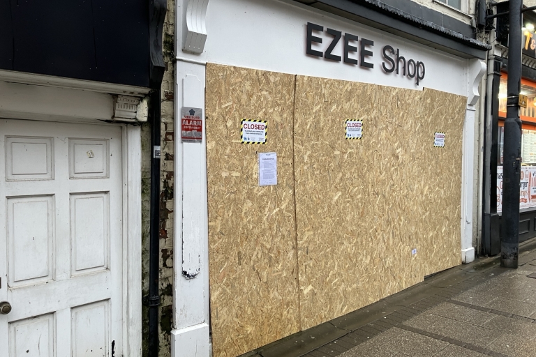 Shop boarded with closure notices on