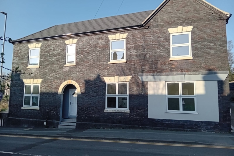 image of the front of a large grey brick home 