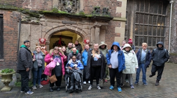 A group of people stood in front of a castle